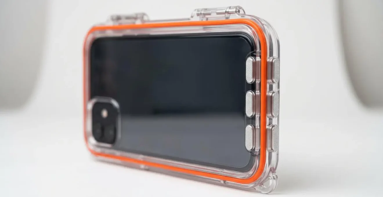 Gros plan sur un caisson étanche moderne pour smartphone, montrant les joints toriques orange et les commandes mécaniques latérales